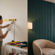 Gabungan proses DIY menampal casing wayar PVC pada dinding dan hasil akhir feature wall bergalur tona hijau gelap yang mewah.